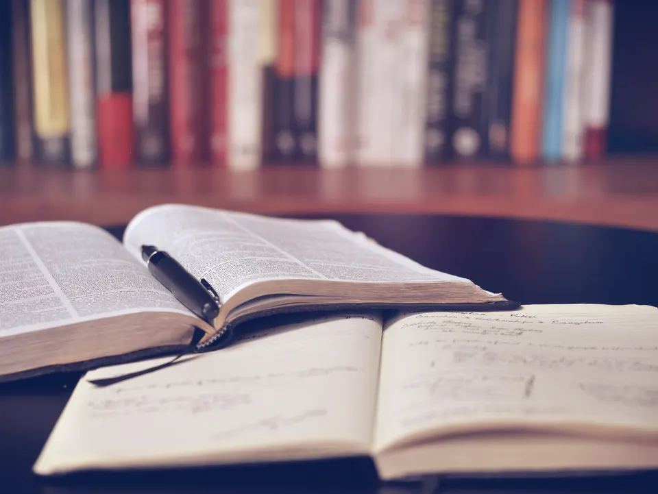 An open notebook and books on a table